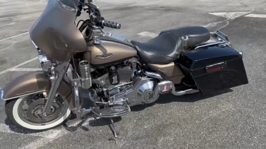 A matte bronze motorcycle with a large front fairing, chrome details, and a black storage box