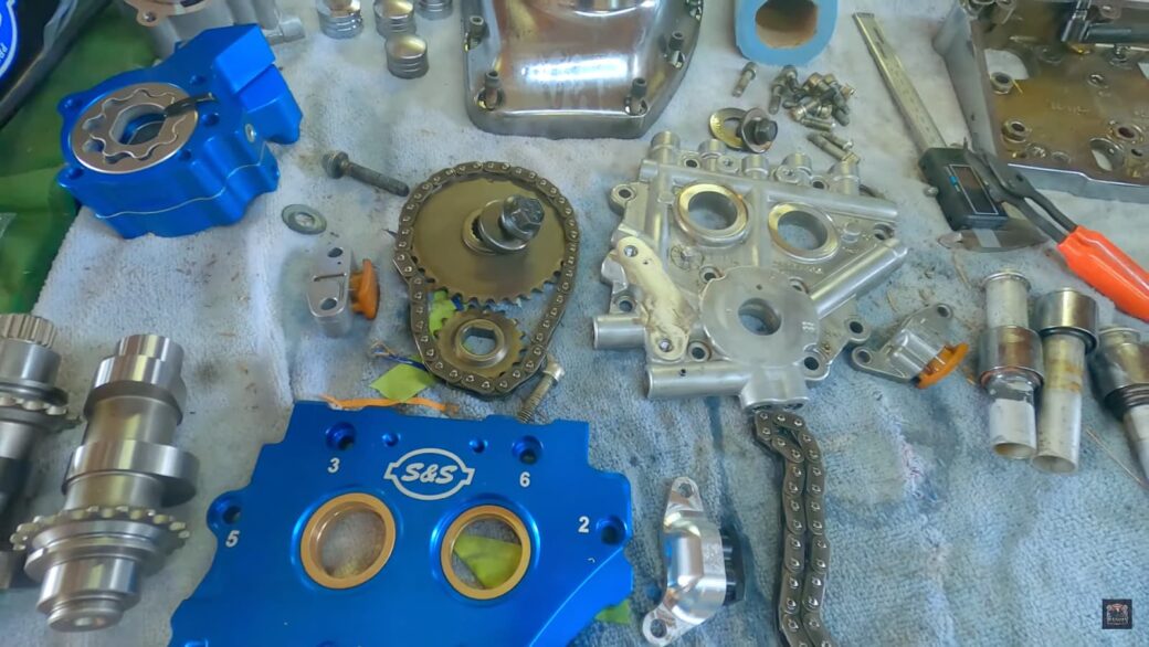 motorcycle parts, blue S&S component, details of engine components and tools on a workshop table