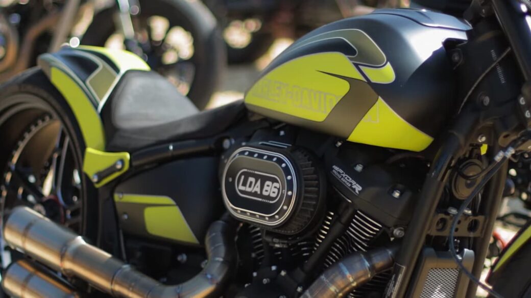 vibrant details of a motorcycle, showcasing its neon yellow accents, "Harley-Davidson" branding, and word LDA 86 on engine badge